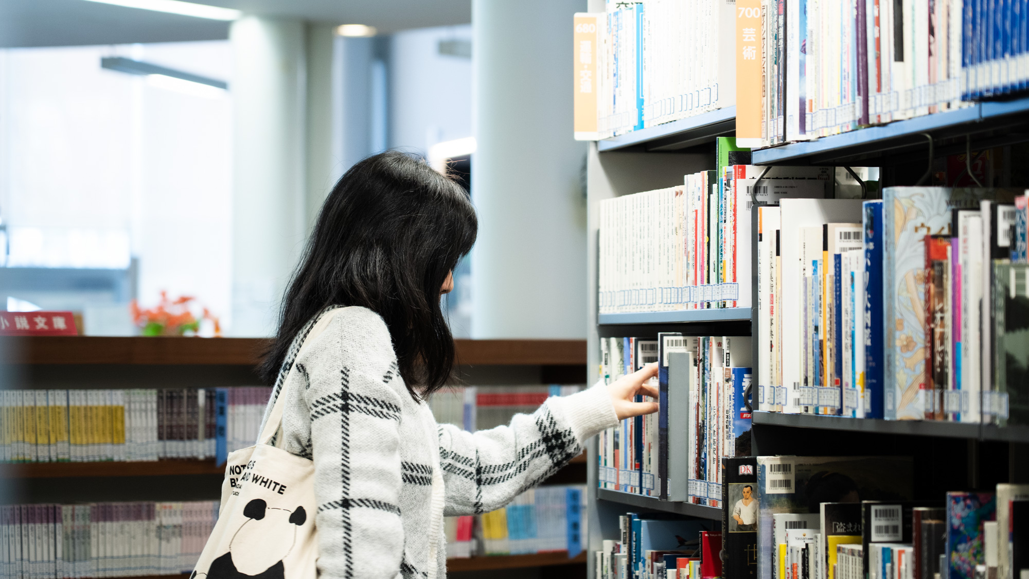 書架から本を手に取る参加者