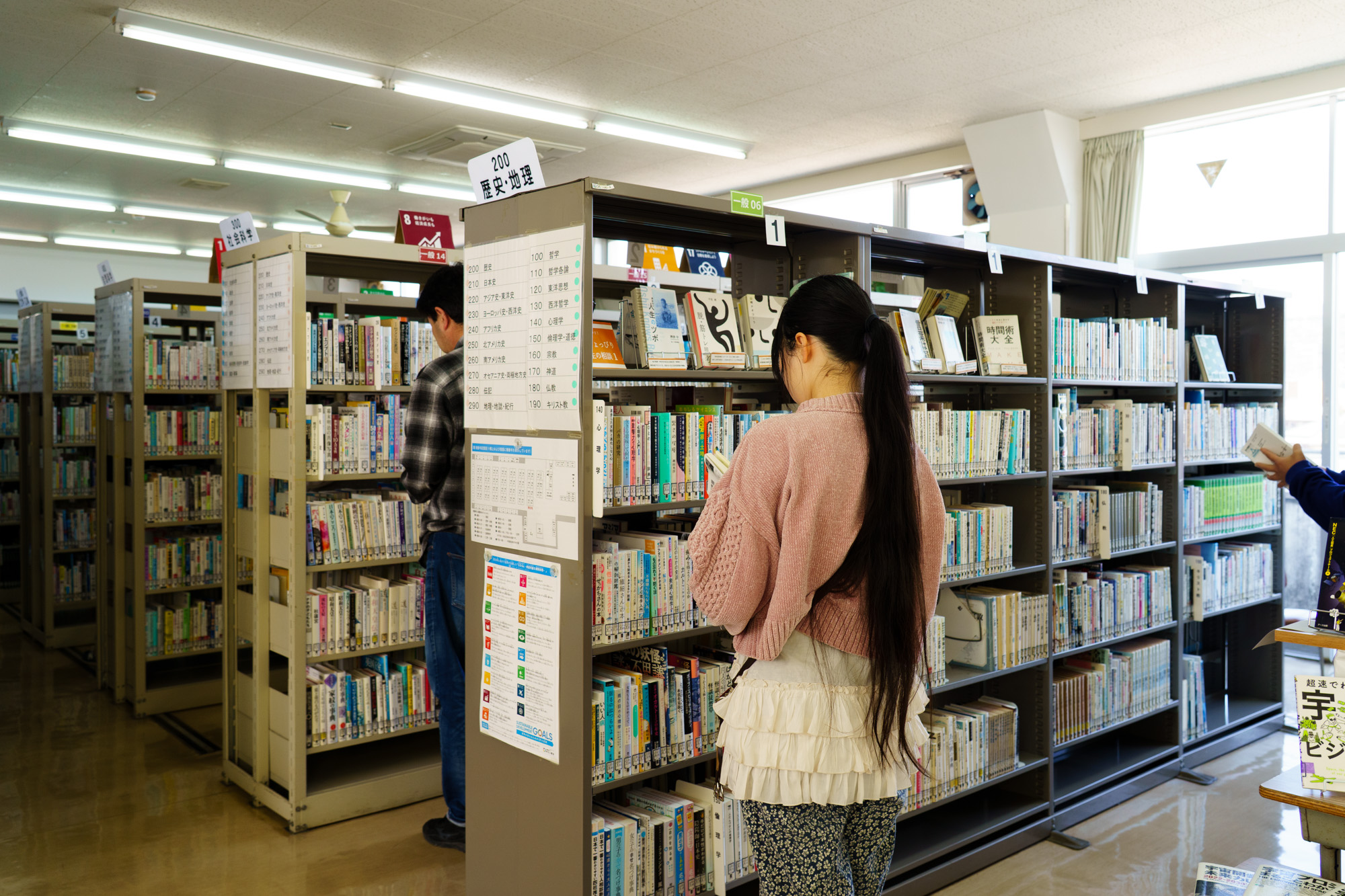 書架から本を選ぶ参加者